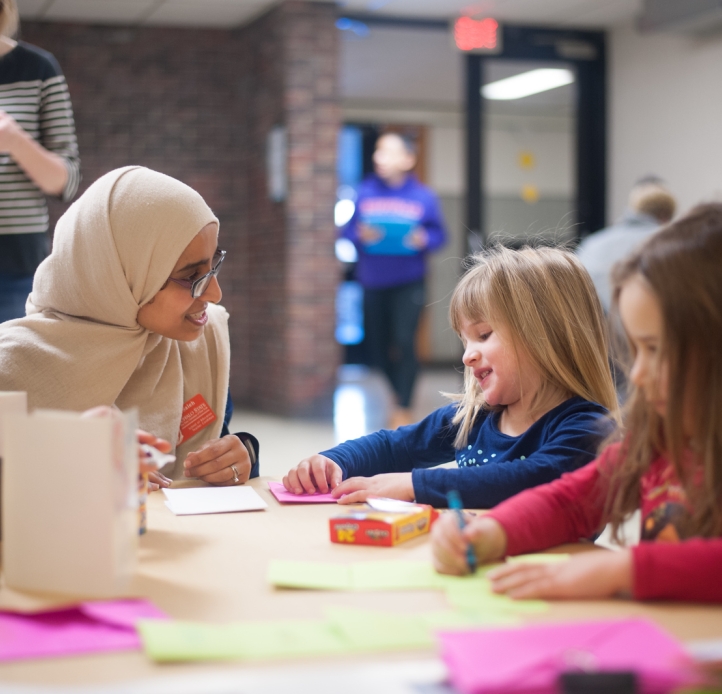Teacher and stident draw with crayons